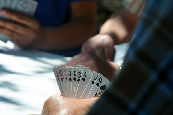 テーブルでカードゲームをする人々